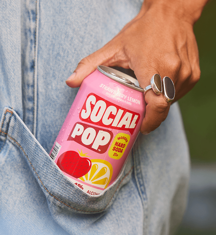 A person pulling a can of Social Pop Strawberry Lemon hard soda from their pocket