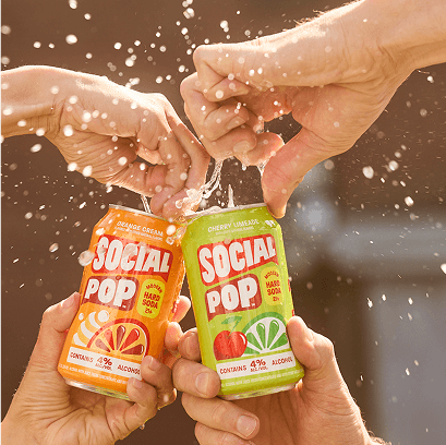 Two people opening cans of Social Pop Hard Soda together