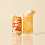A can and glass of Orange Cream Social Pop