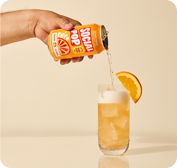 Orange Cream Hard Soda being poured from a can into a glass