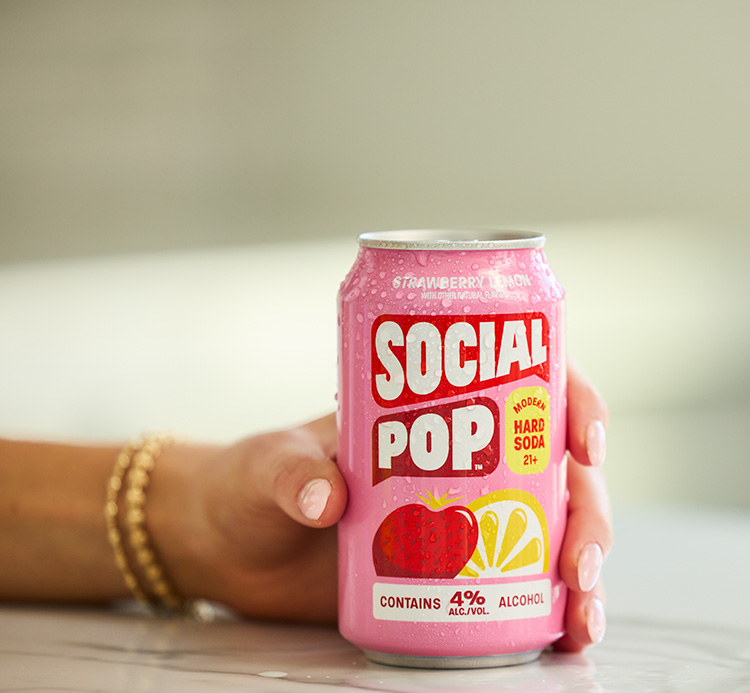 A hand holding a can of Social Pop